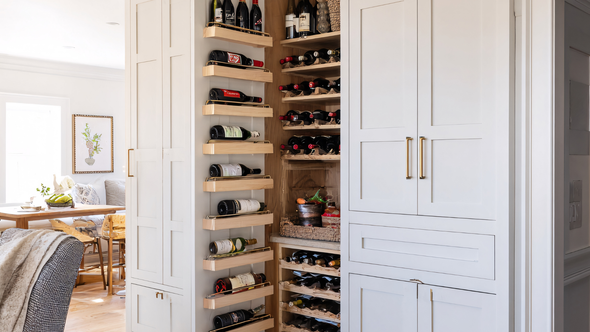 Wine storage cabinet with built-in racks, featuring various bottles and adjacent storage.