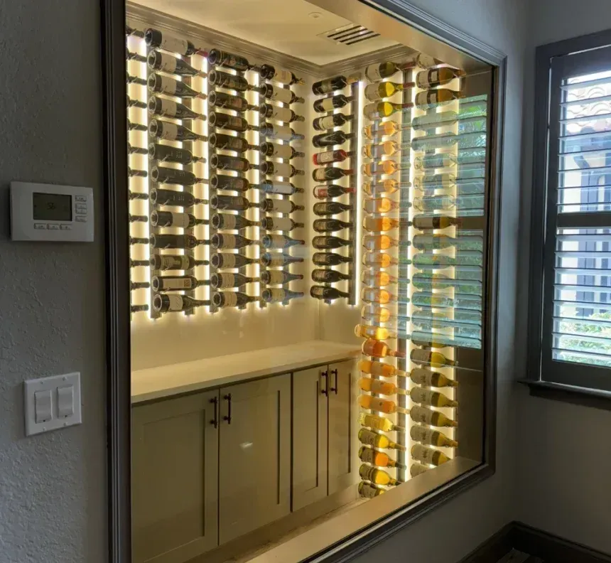 Wine cellar display with bottles illuminated by LED lights, built into a wall.