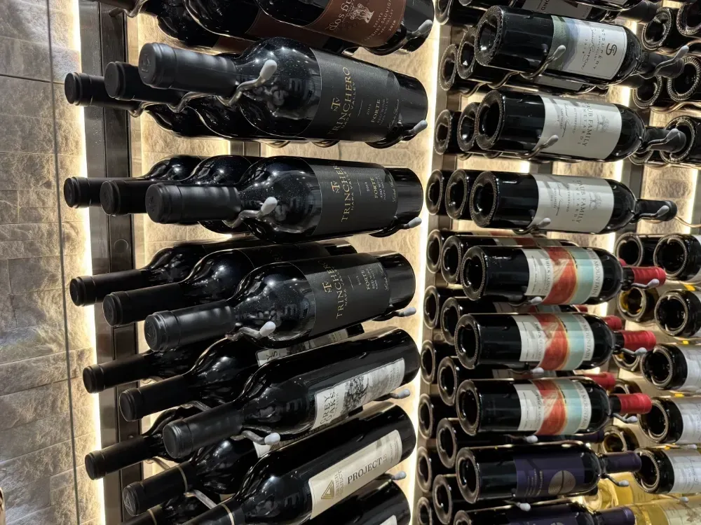 Wine bottles stored on shelves in a well-lit display.