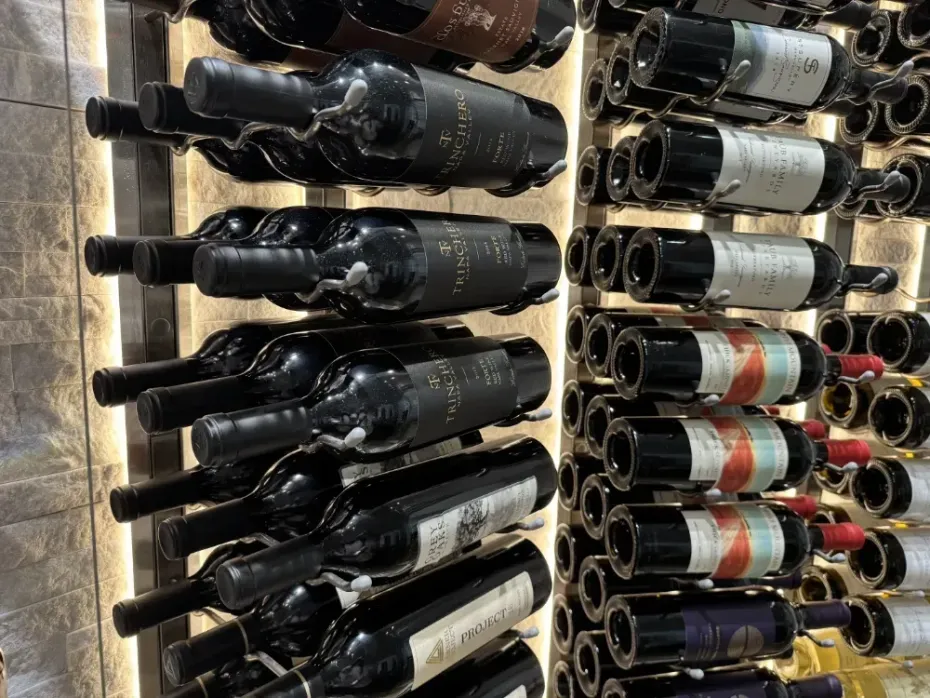 Wine bottles stored on shelves in a well-lit display.