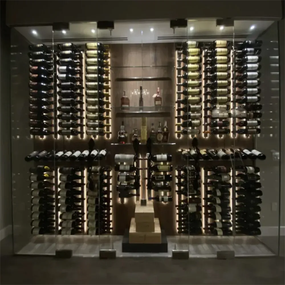 Glass-enclosed wine cellar with lit shelves displaying numerous wine bottles, and some liquor bottles.