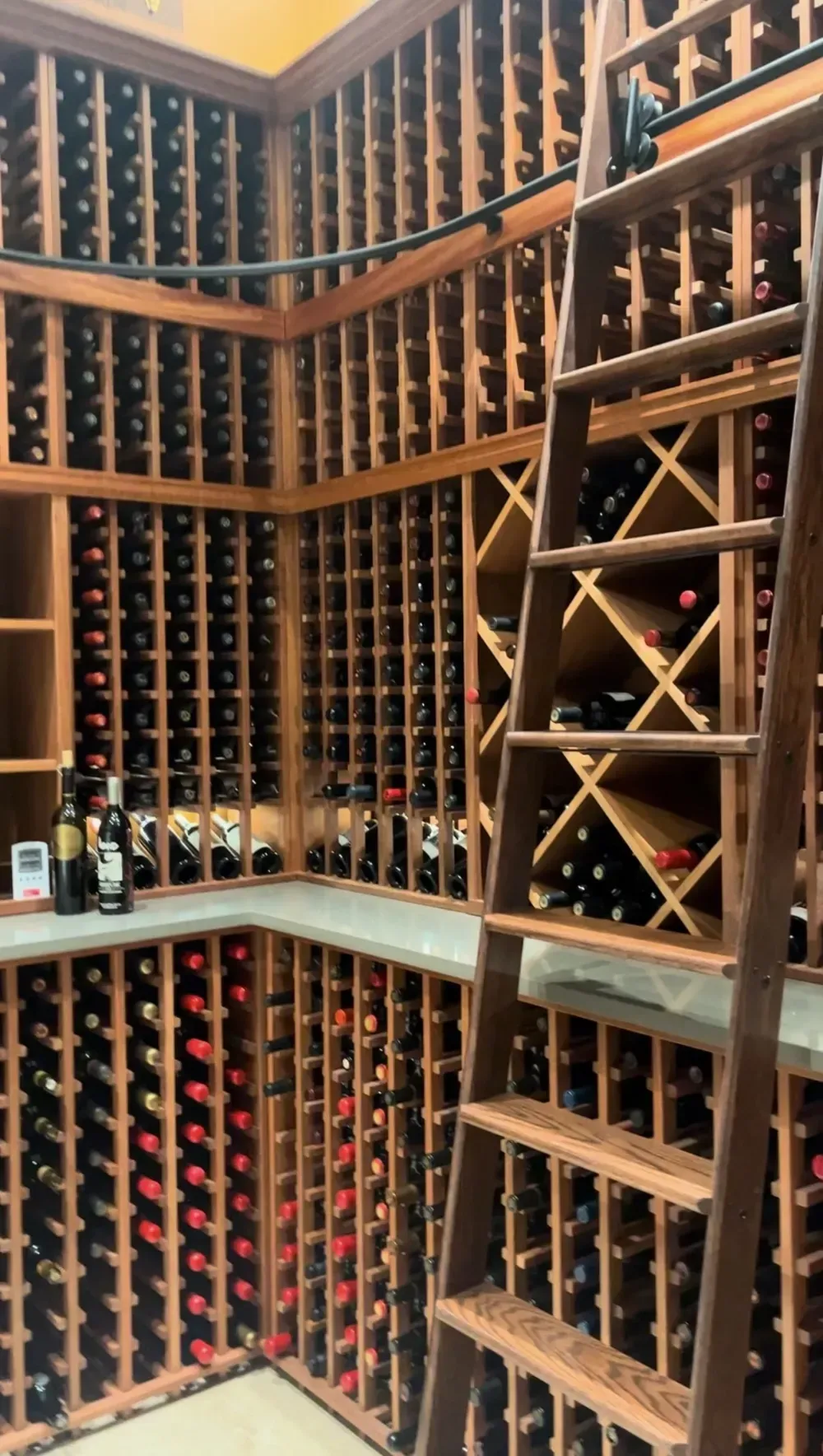 Wine cellar with wooden racks filled with wine bottles, wooden ladder.