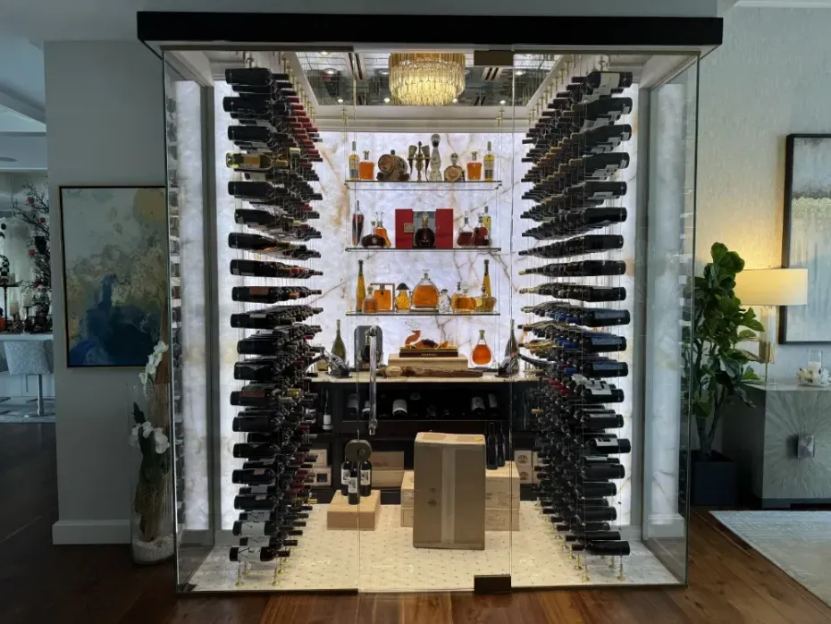 Wine cellar with illuminated bottles on shelves, marble walls, and a central display area.