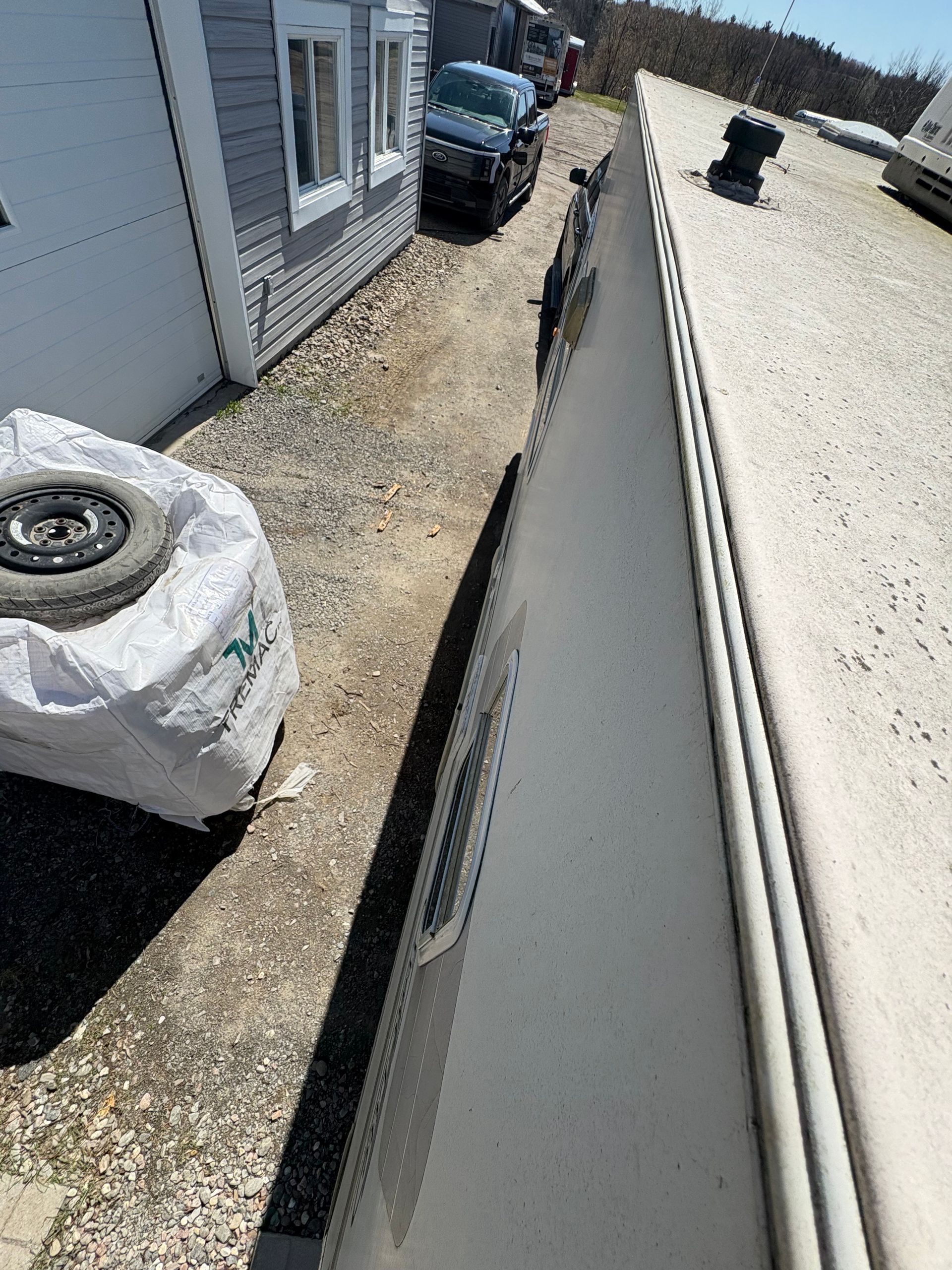 Une voiture est garée sur le côté d'un bâtiment à côté d'un pneu.