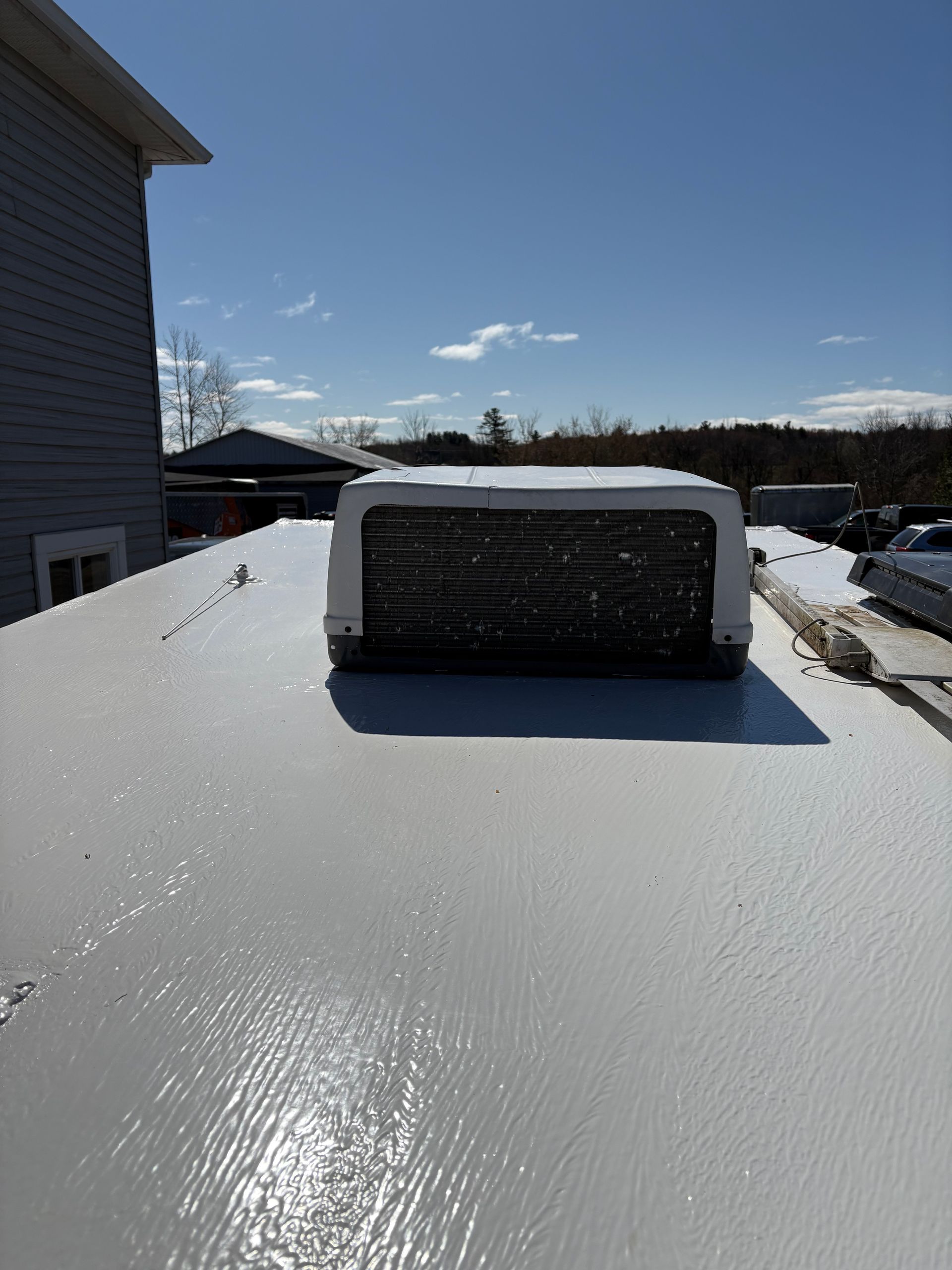 Un toit blanc avec un système de ventilation au-dessus