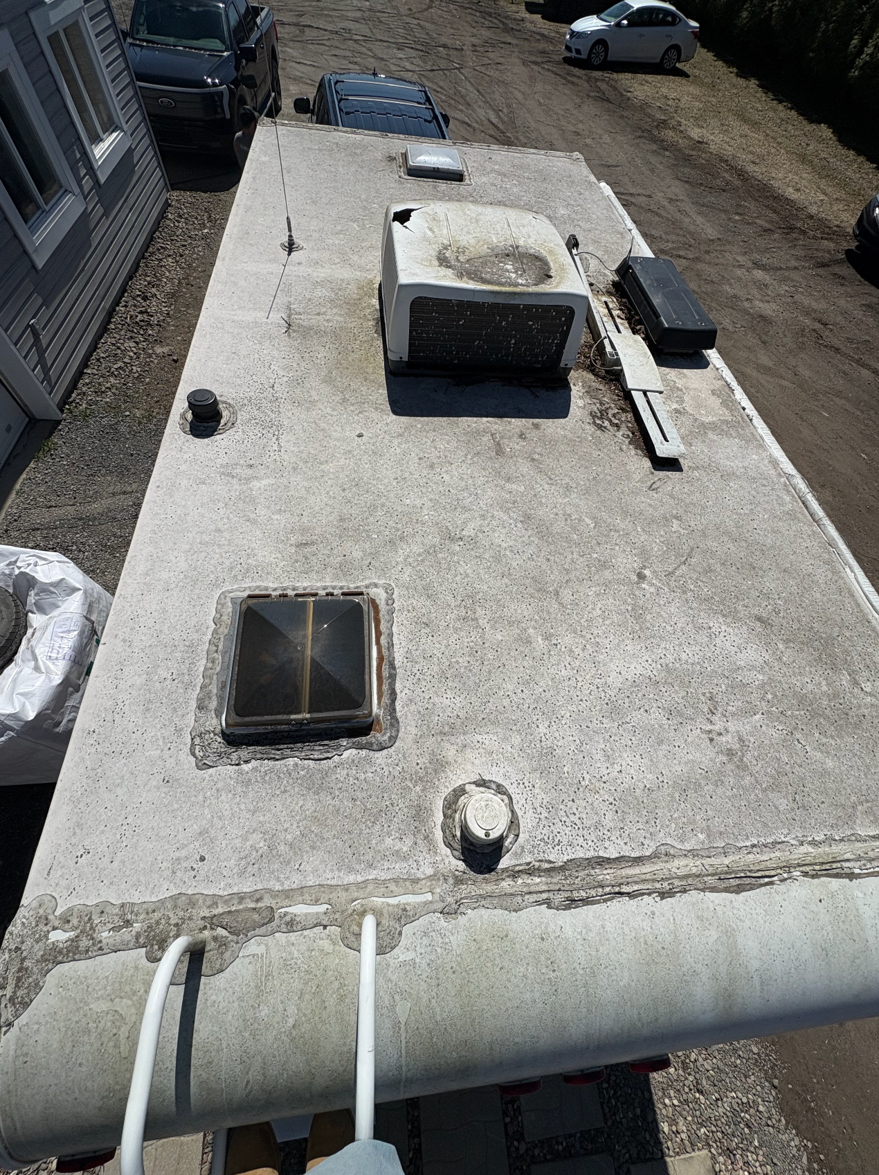 Une vue aérienne du toit d'un camping-car garé devant une maison.