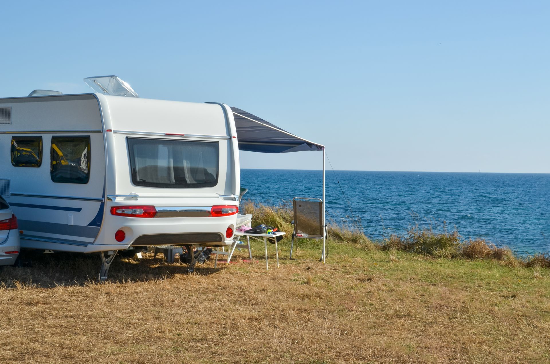 Un camping-car est garé sur la plage à côté de l'océan.