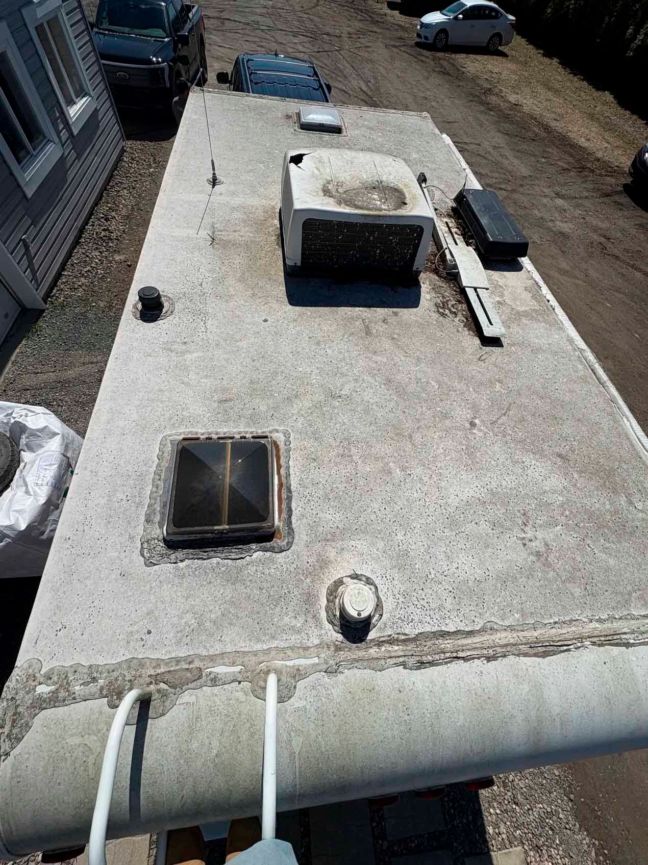 Une vue aérienne du toit d'un camping-car garé devant une maison.