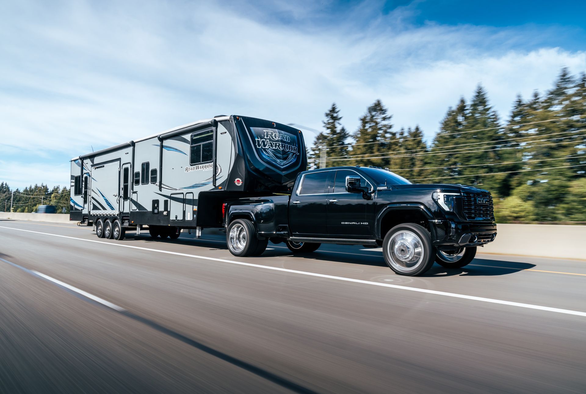 Un camion noir tracte une remorque sur une autoroute.