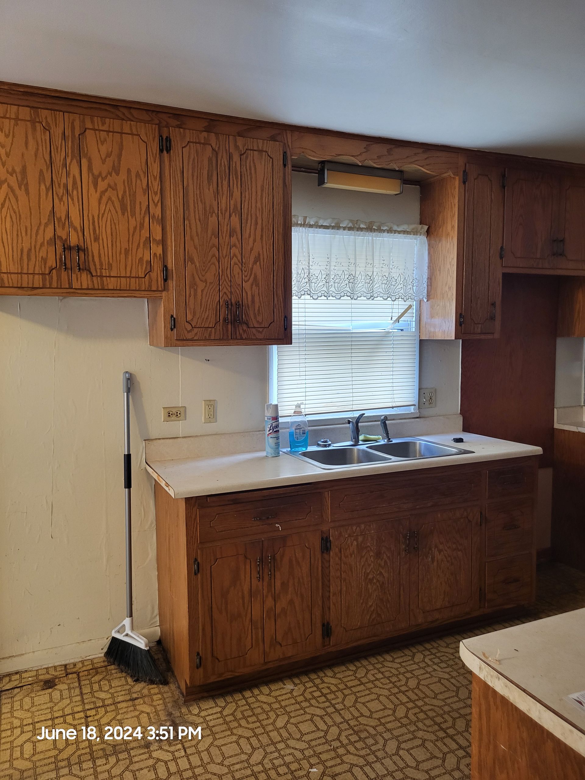 Before photo of a renovated kitchen with wood cabinets