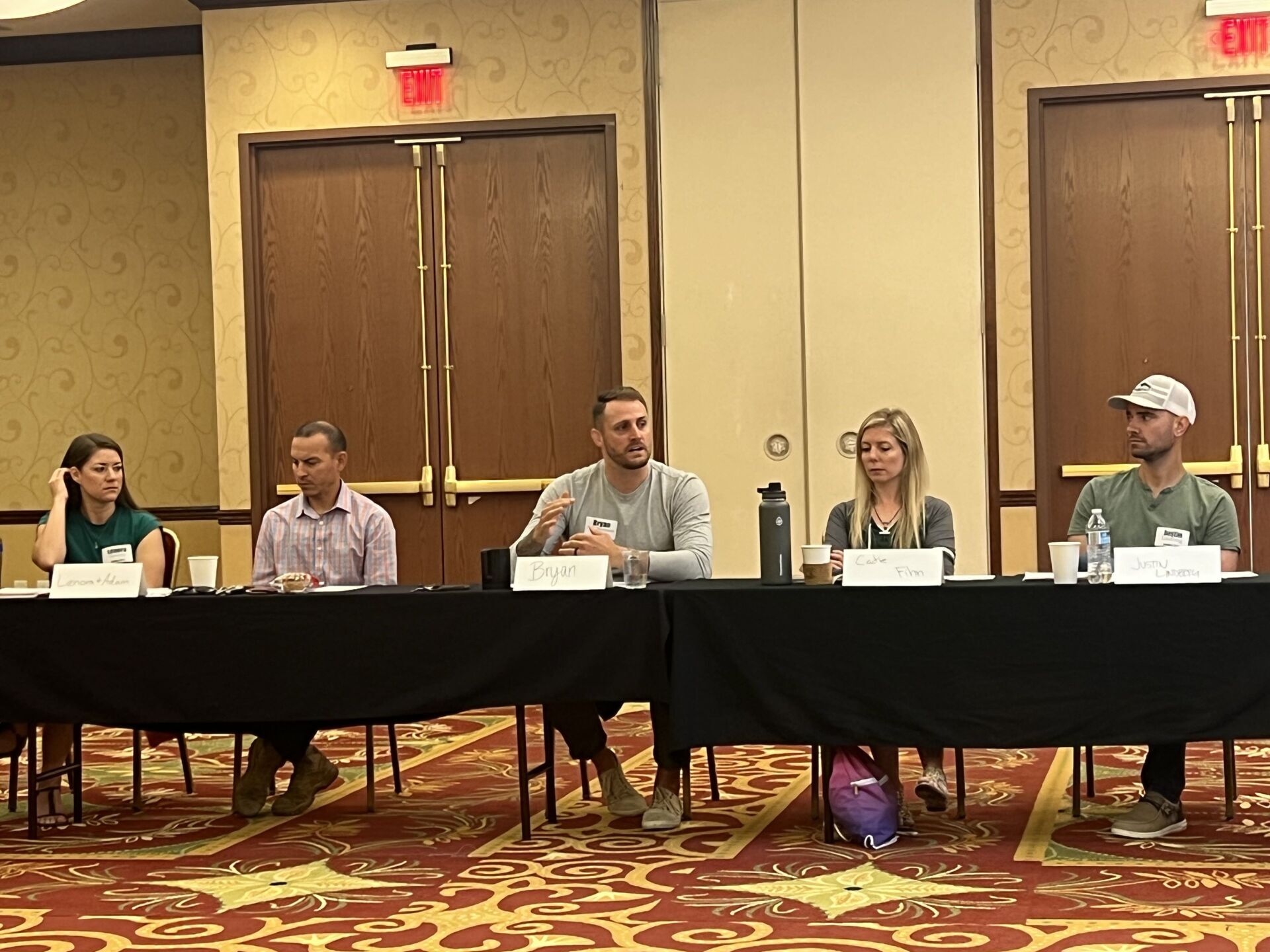 A group of people are sitting at a long table in a conference room.