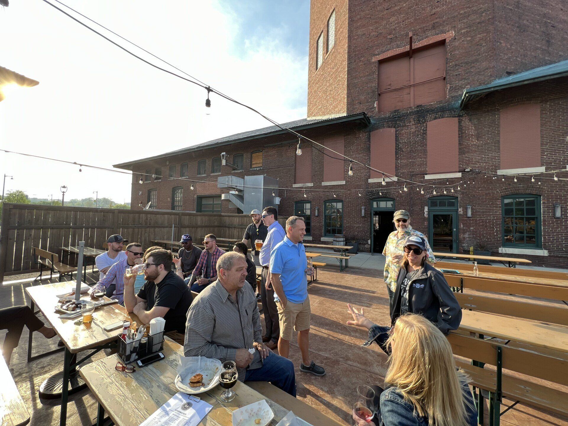 A group of people are sitting at tables outside of a building.