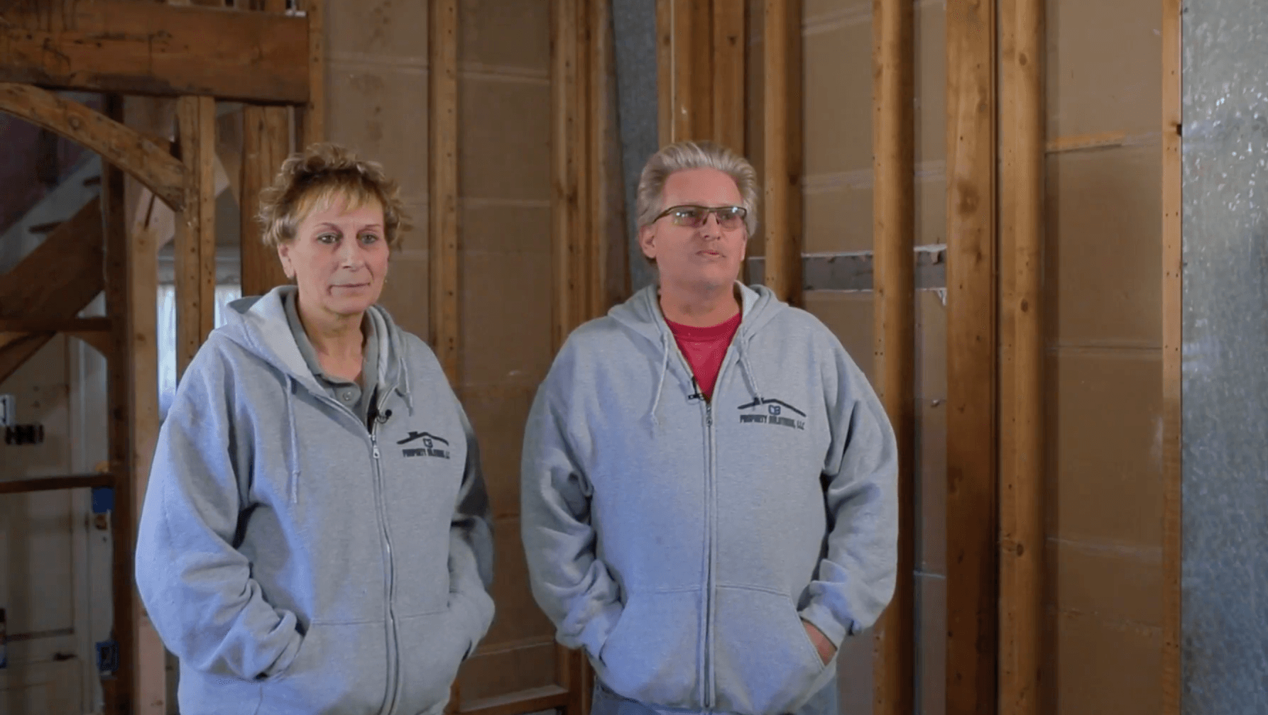 A man and a woman are standing next to each other in a building under construction.