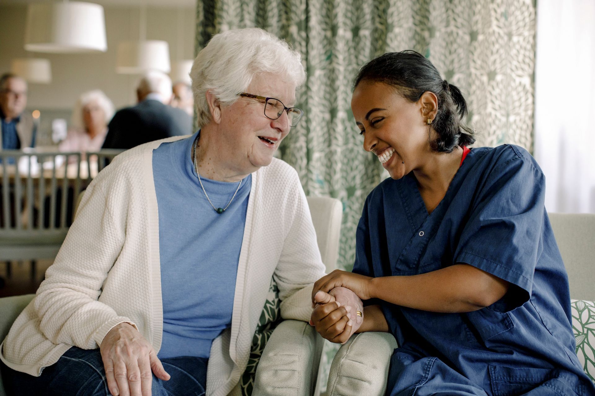 An elderly woman is sitting in a chair - Middletown, CT - Chestelm Adult Day Services