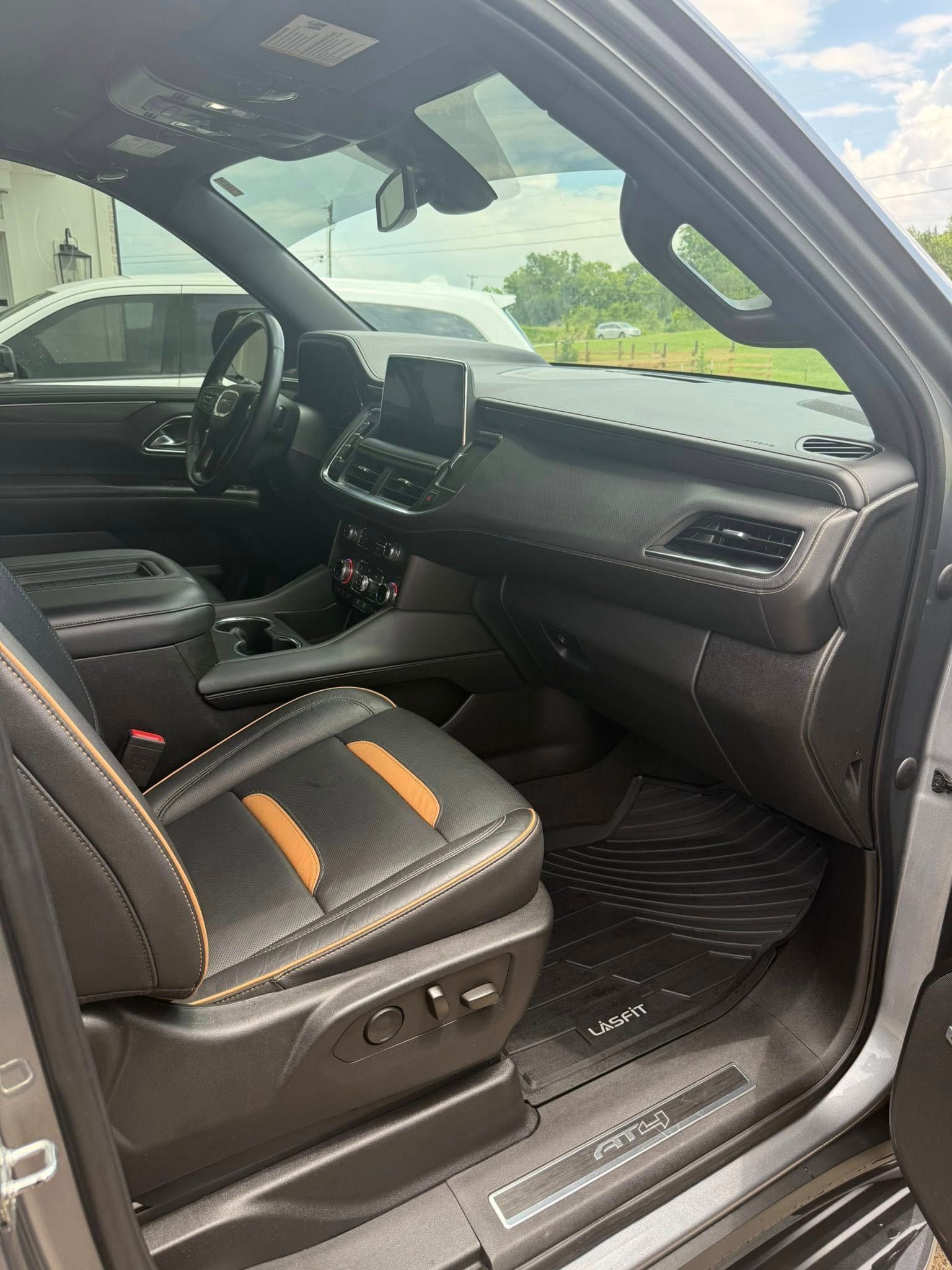 Open car door showing black leather interior with orange accents and dashboard view