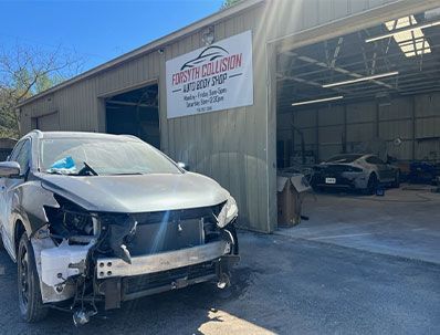 a damaged car is parked in front of a garage  at Forsyth Collision in Cumming GA