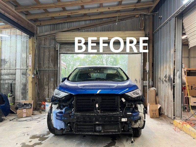 a blue car is sitting in a garage before being repaired  at Forsyth Collision in Cumming GA