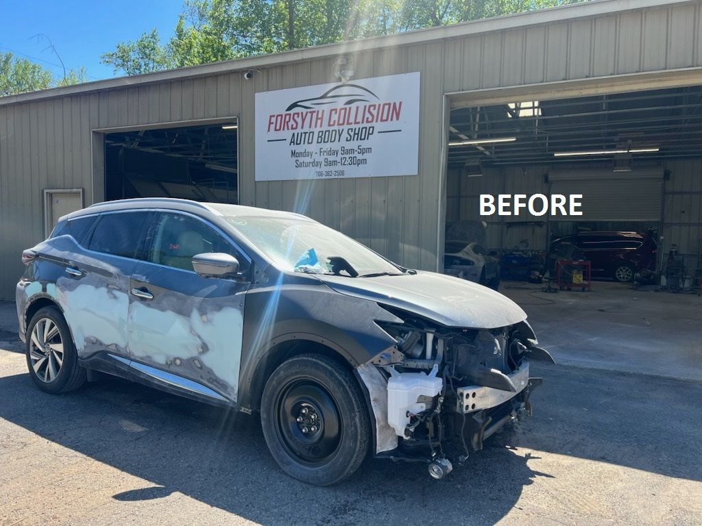 a car that has been damaged is parked in front of a garage  at Forsyth Collision in Cumming GA