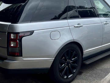 a silver range rover is parked in a parking lot .