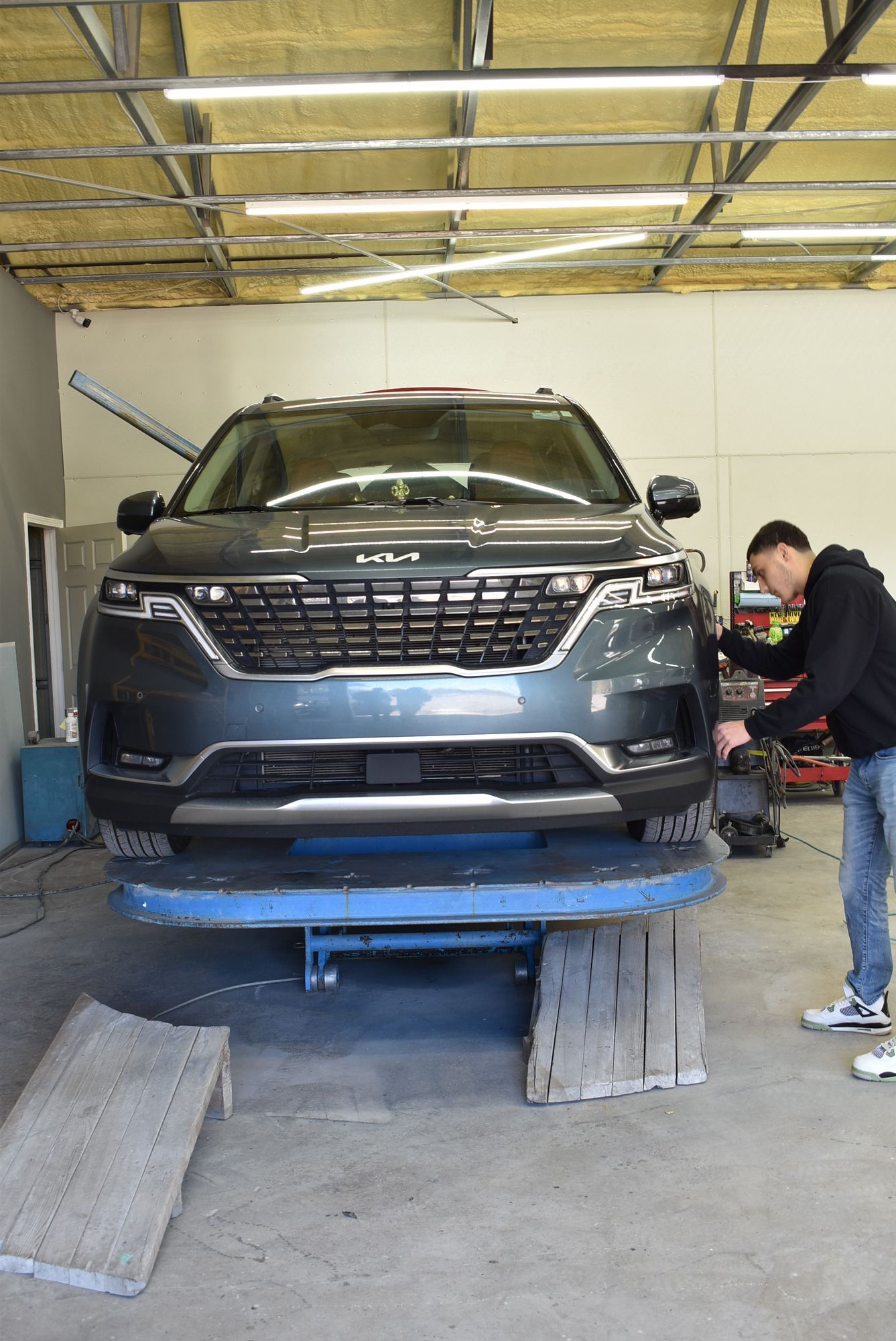 a man is working on a car frame  at Forsyth Collision in Cumming GA.