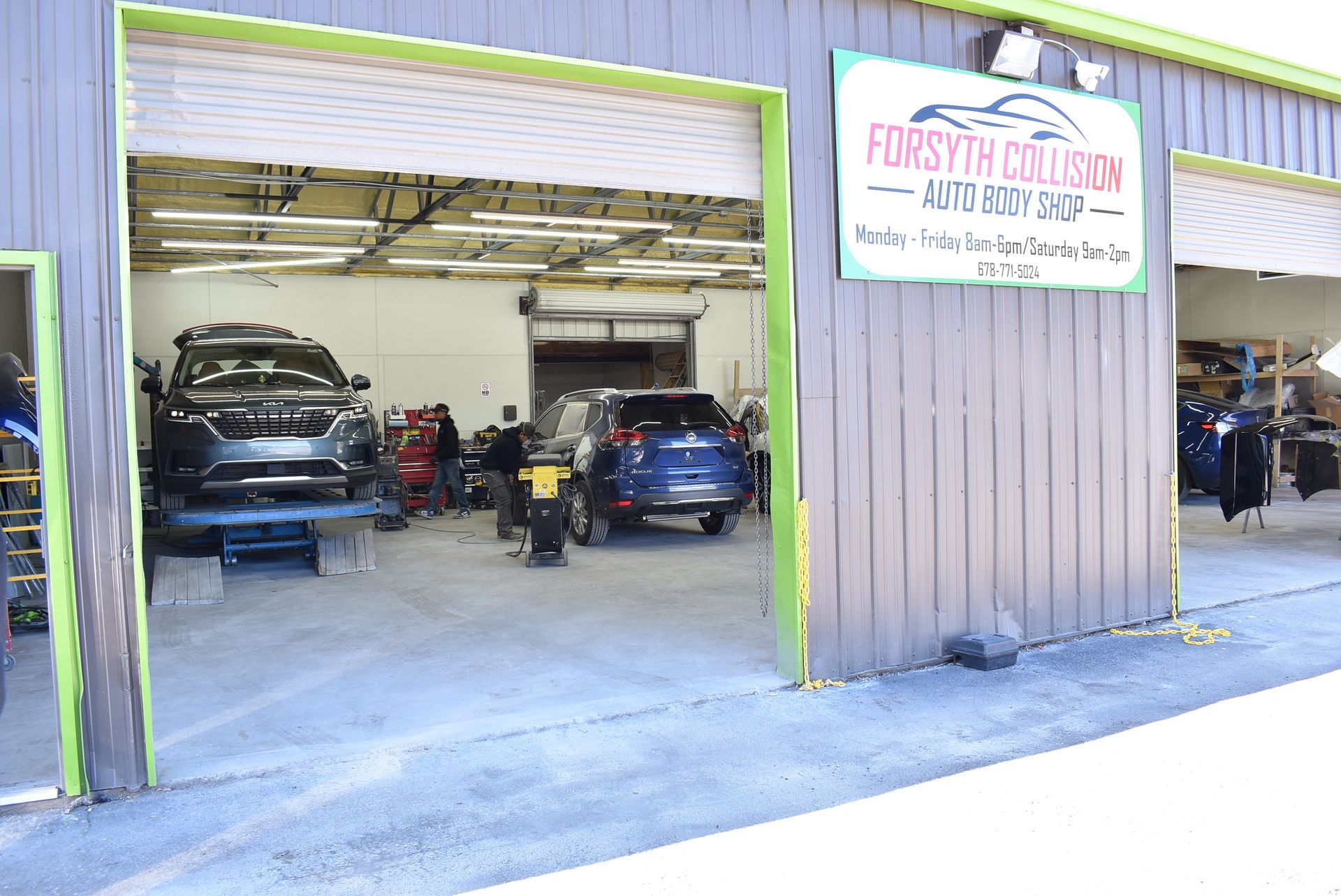 A garage with cars parked inside of it and a sign on the side of the building.