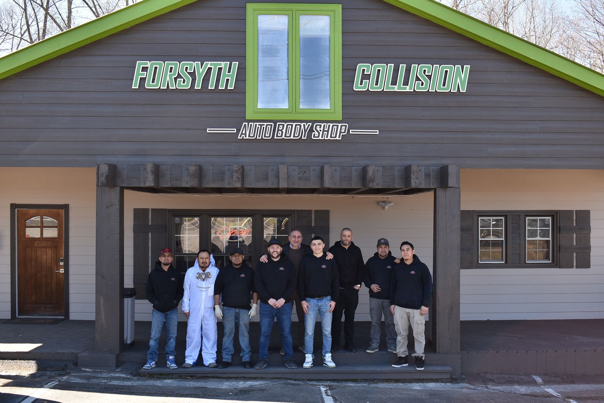a group of people standing in front of a building that says forsyth collision