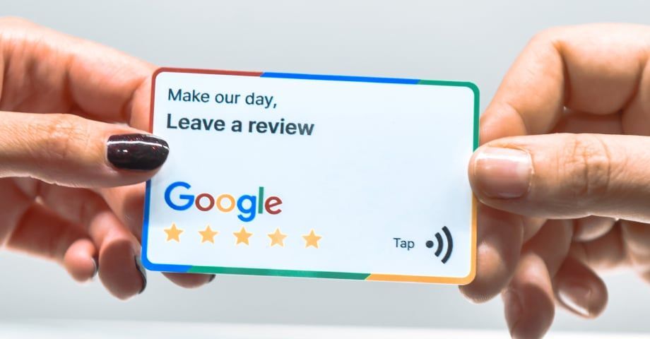 Hands holding a Google review card: 