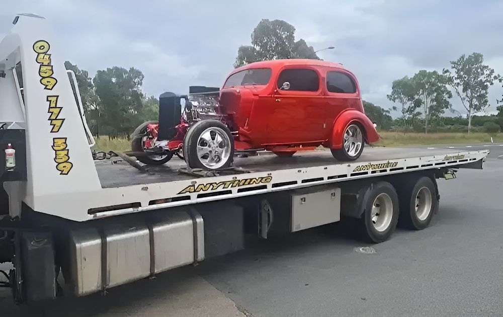 A Red Car Is Sitting On Top Of A Tow Truck — A1 Loco's Towing In West Rockhampton, QLD