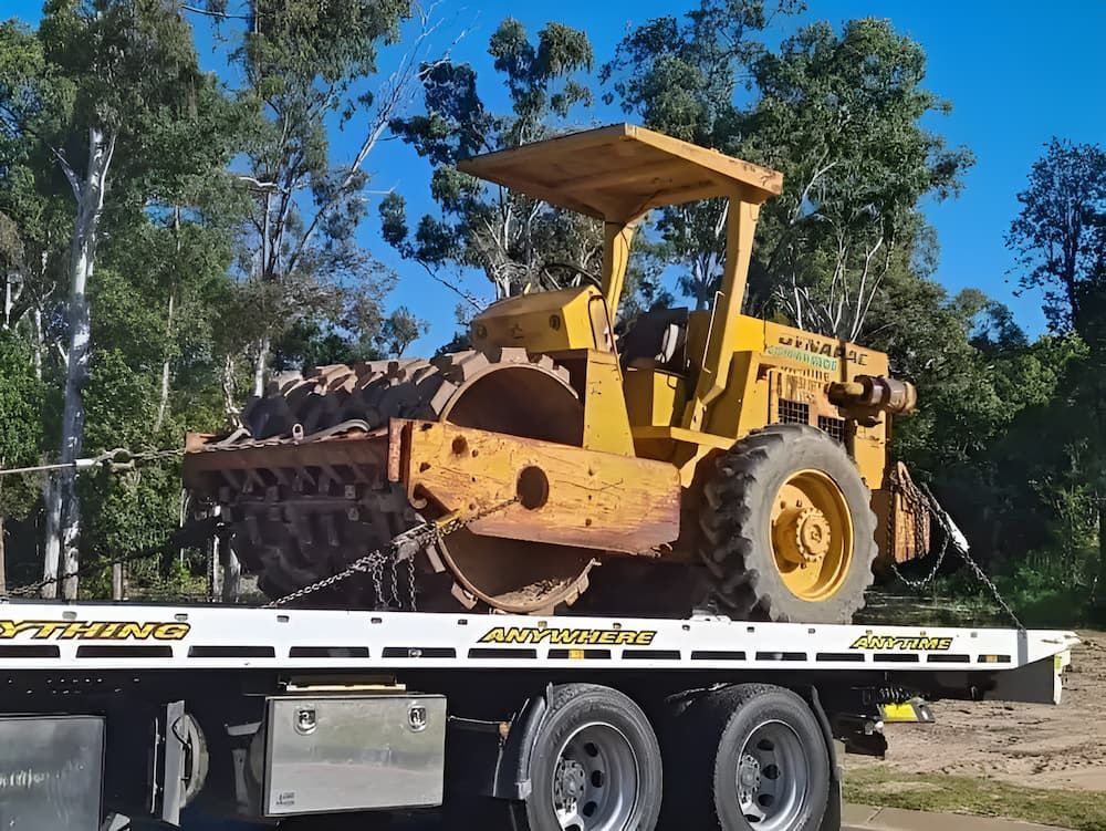 A Yellow Tractor Is On The Back Of A Tow Truck — A1 Loco's Towing In West Rockhampton, QLD