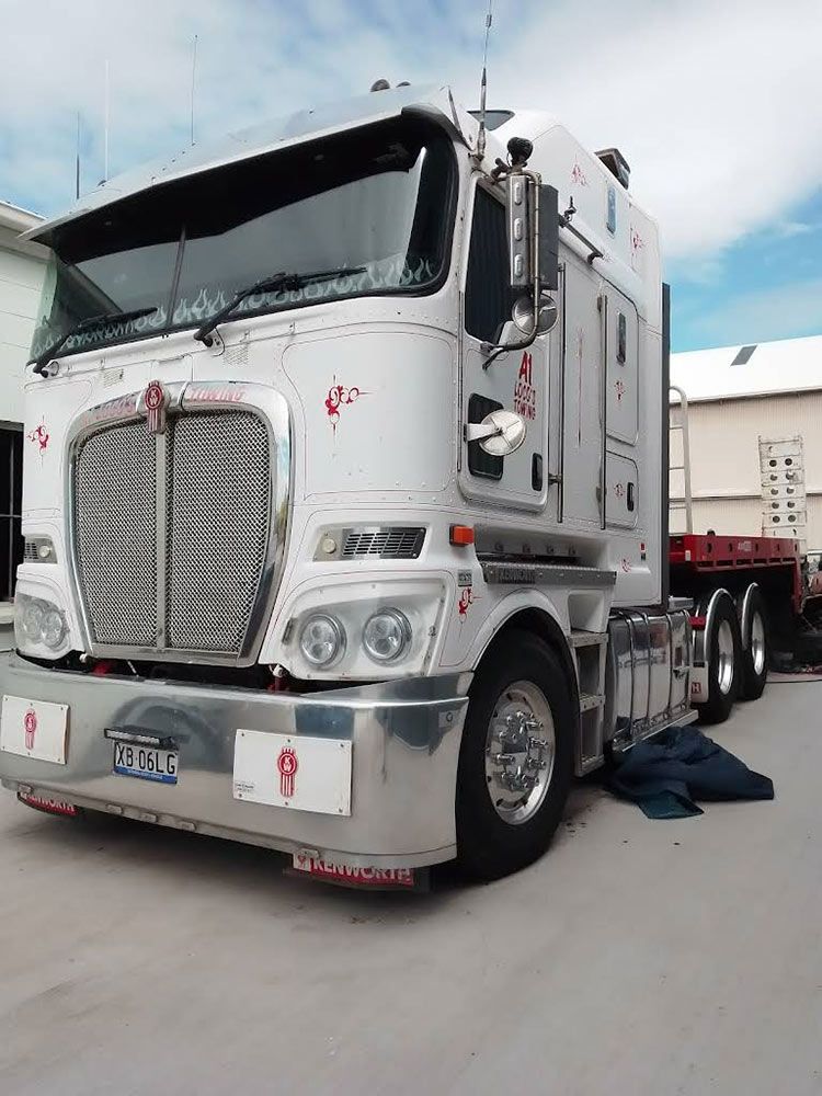 White Kenworth Semi-truck Parked in Front of a Building. Shiny Chrome Accents — A1 Loco's Towing in Rockhampton, QLD