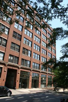 A large brick building with lots of windows and a car parked in front of it