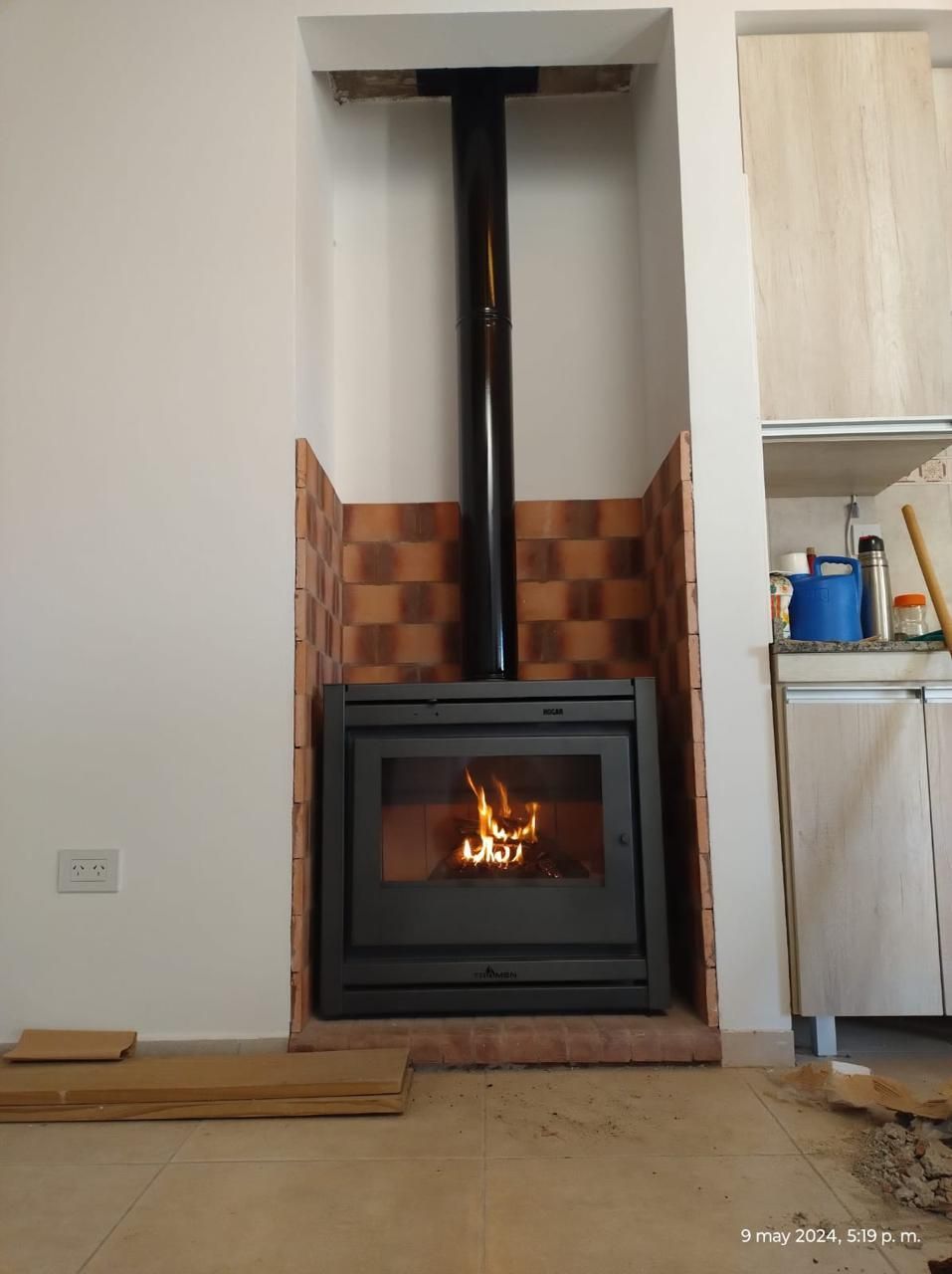 Se está instalando una chimenea en un rincón de una habitación.