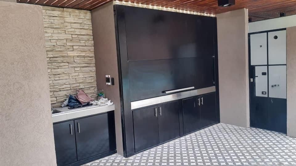 Una cocina con gabinetes negros y una pared de ladrillo.