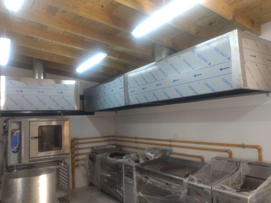 Una cocina con electrodomésticos de acero inoxidable y techo de madera.