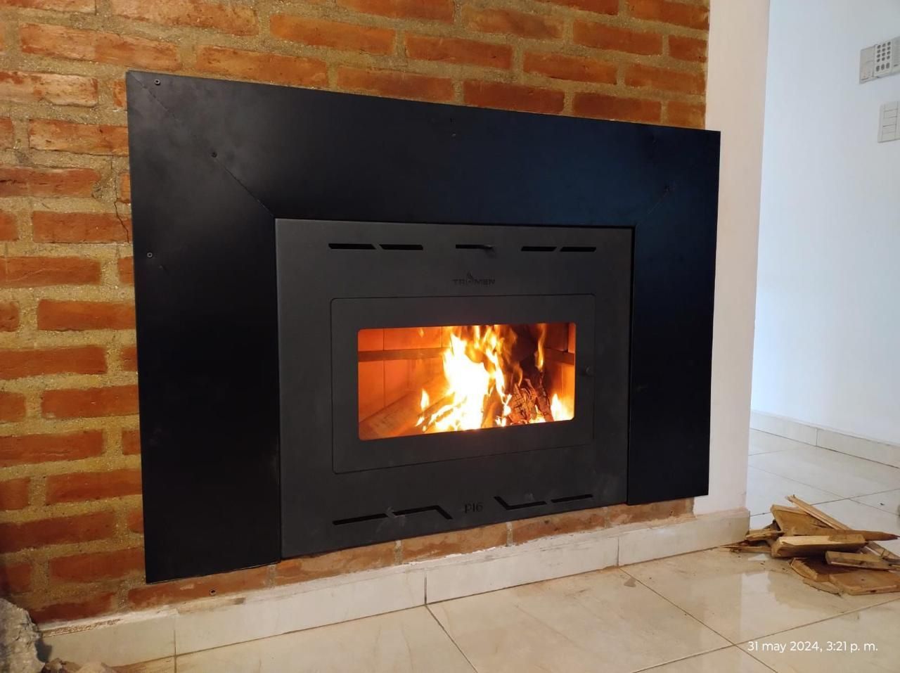 Una chimenea está empotrada en una pared de ladrillos.