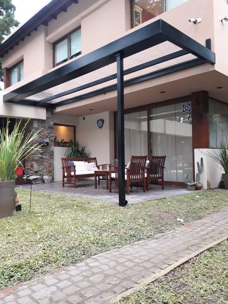 Una casa con un patio con un dosel encima.