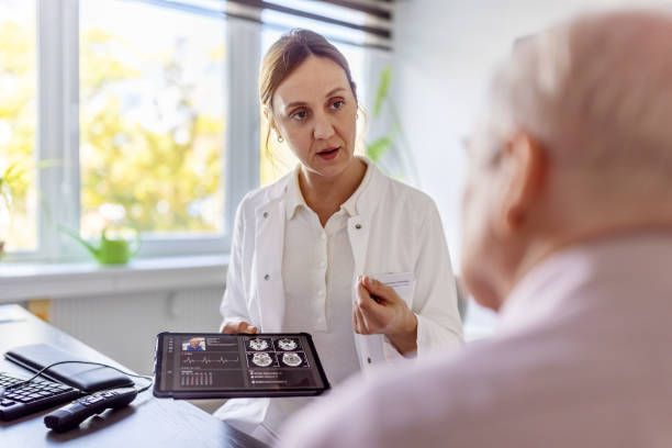 A doctor is showing a tablet to discuss a brain scan with a patient.