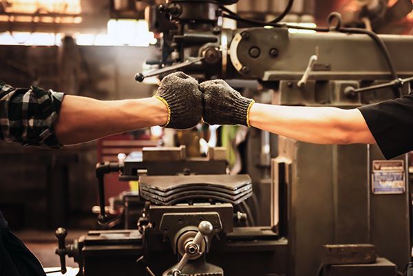 Two people fist bumping in an industrial setting representing a metaphor for sponsorships, partnerships, and affiliate marketing.