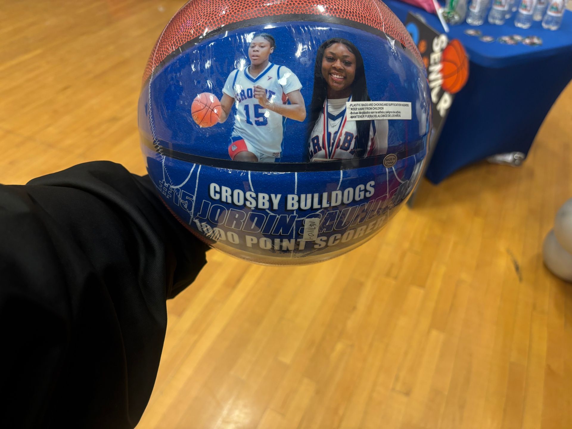 A souvenir basketball for a 1000-point scorer for the Crosby Bulldogs, featuring photos of the player in uniform.