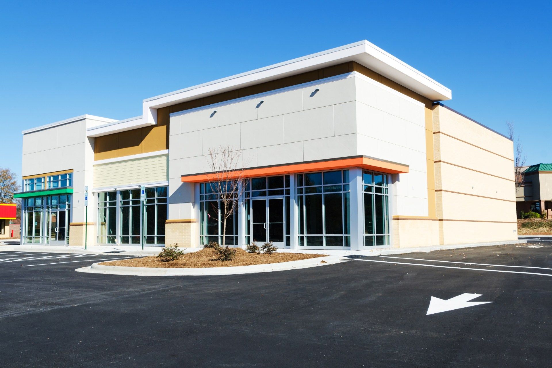 A large building with a lot of windows and a parking lot in front of it.