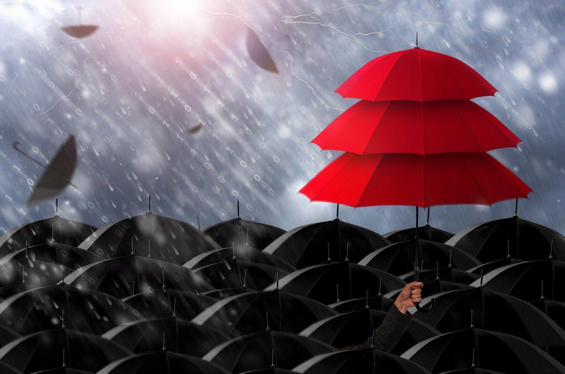 Three red umbrellas are stacked on top of each other in the rain