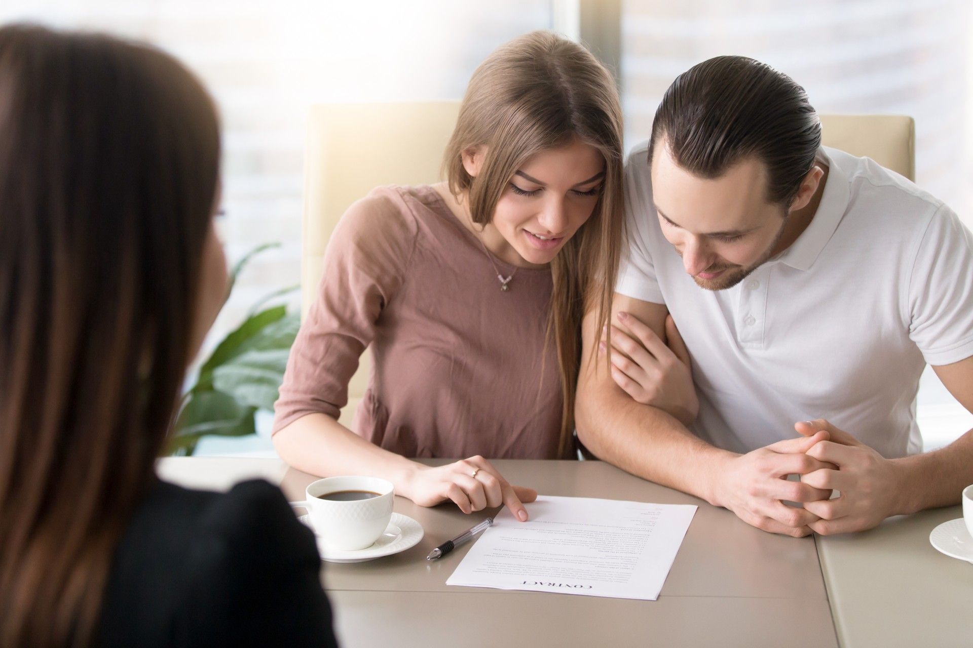 A man and a woman are sitting at a table looking at a piece of paper.