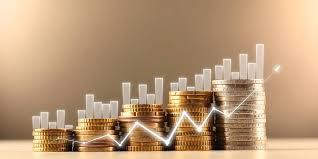 Stacks of gold coins representing a bar chart with an upward-trending white line graph against a warm-toned background.