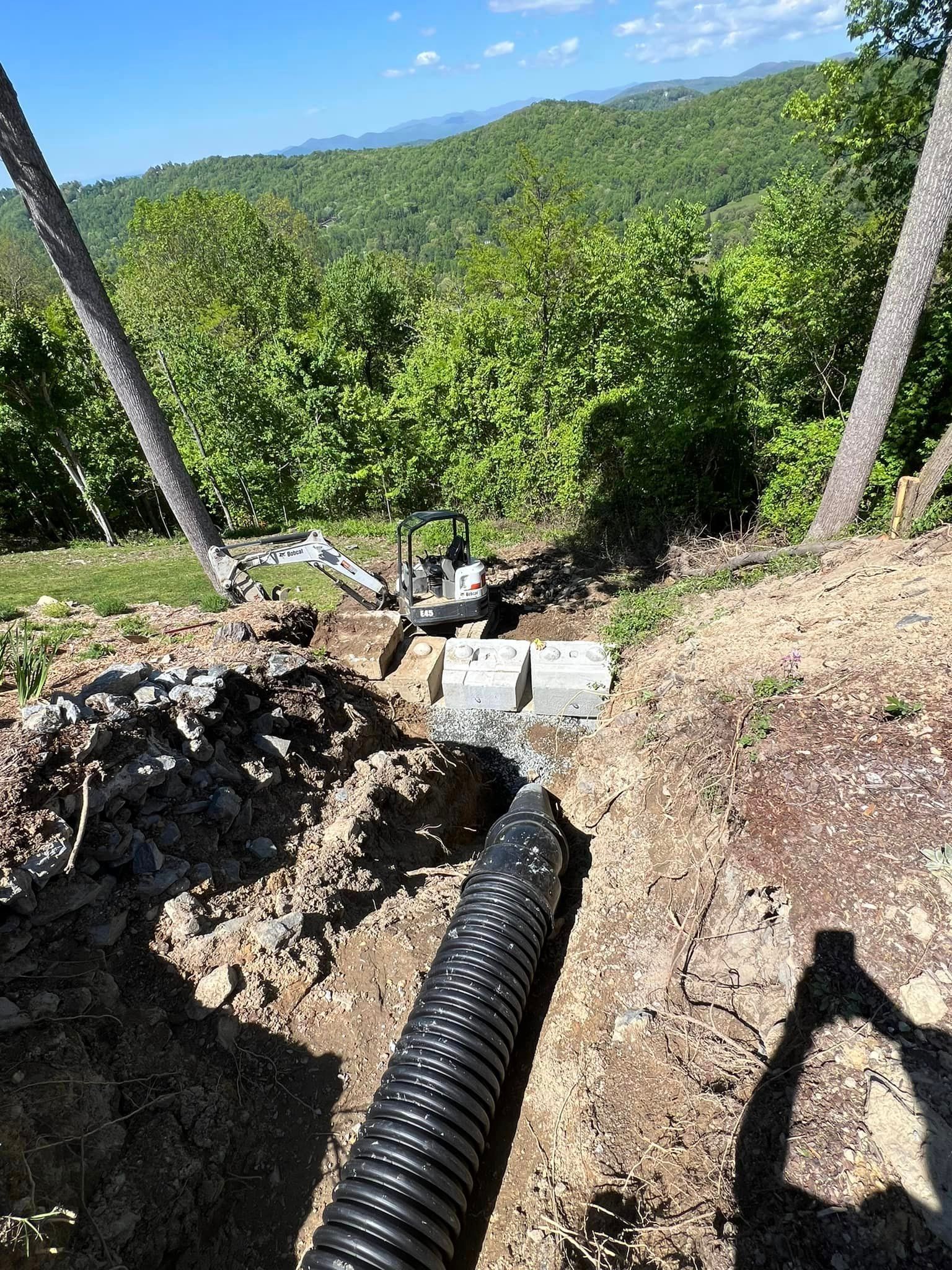 A hose is laying in the dirt on top of a hill.