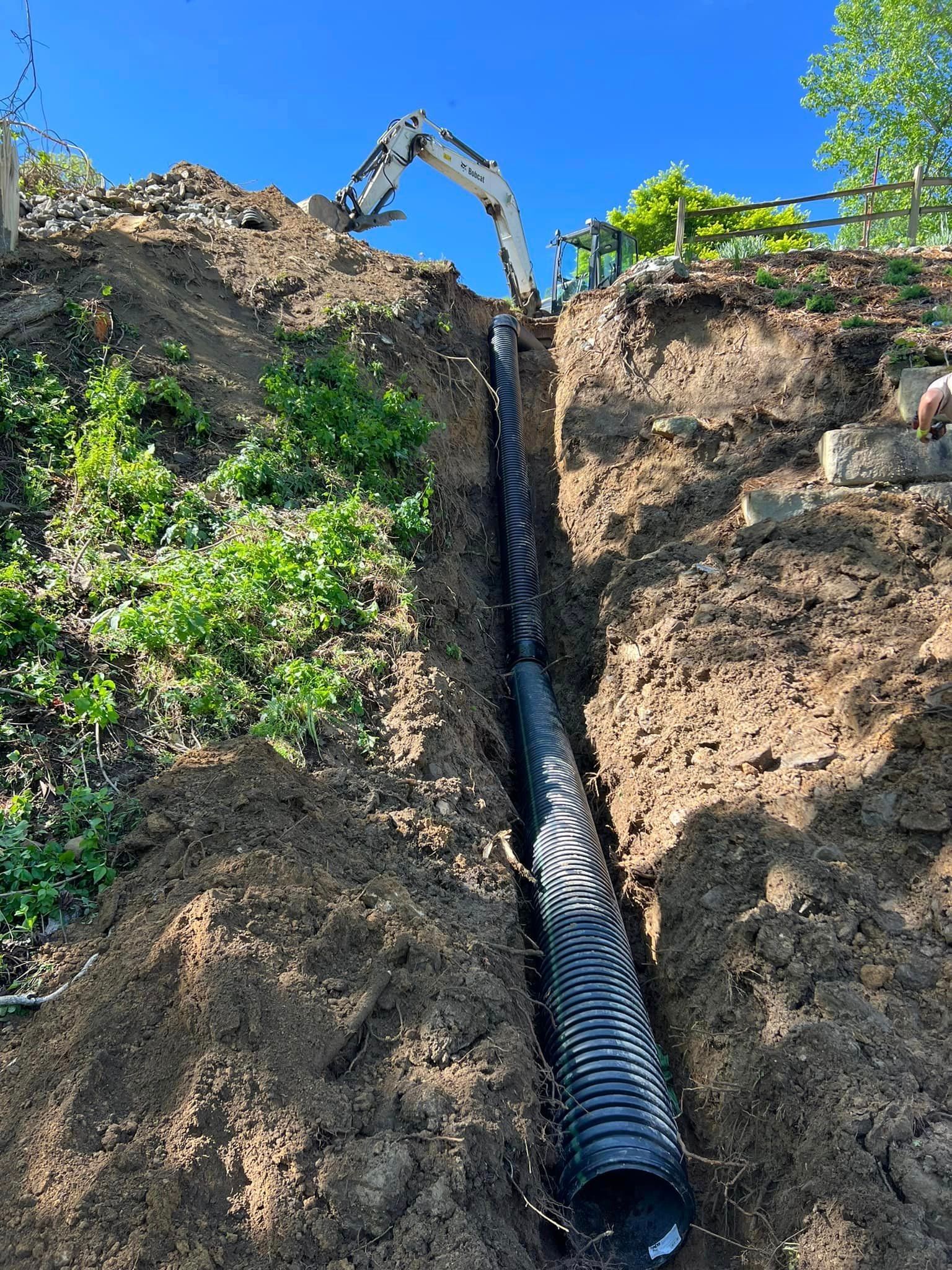 A large pipe is being installed in the dirt.