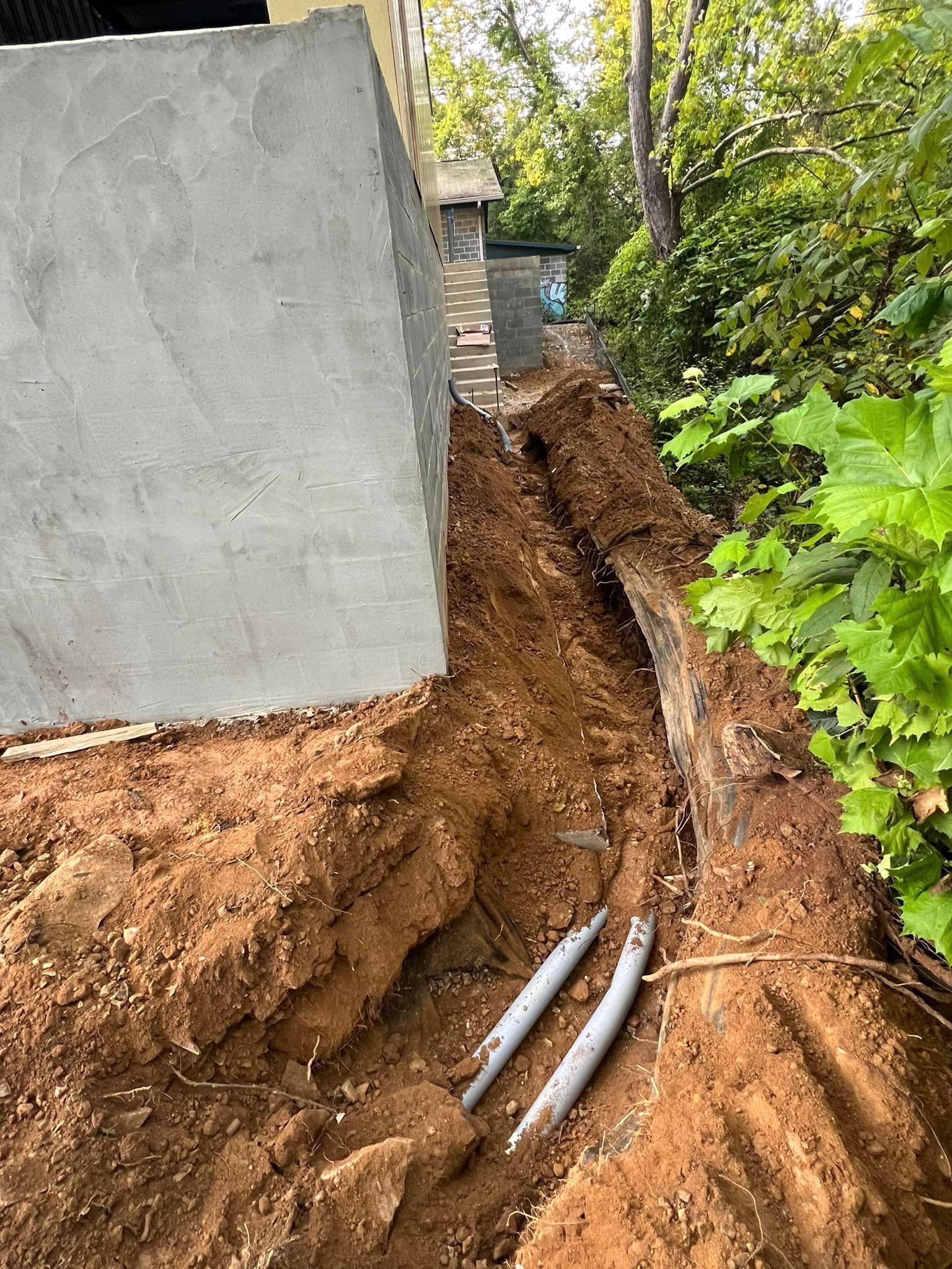 A concrete wall is being built next to a pile of dirt.