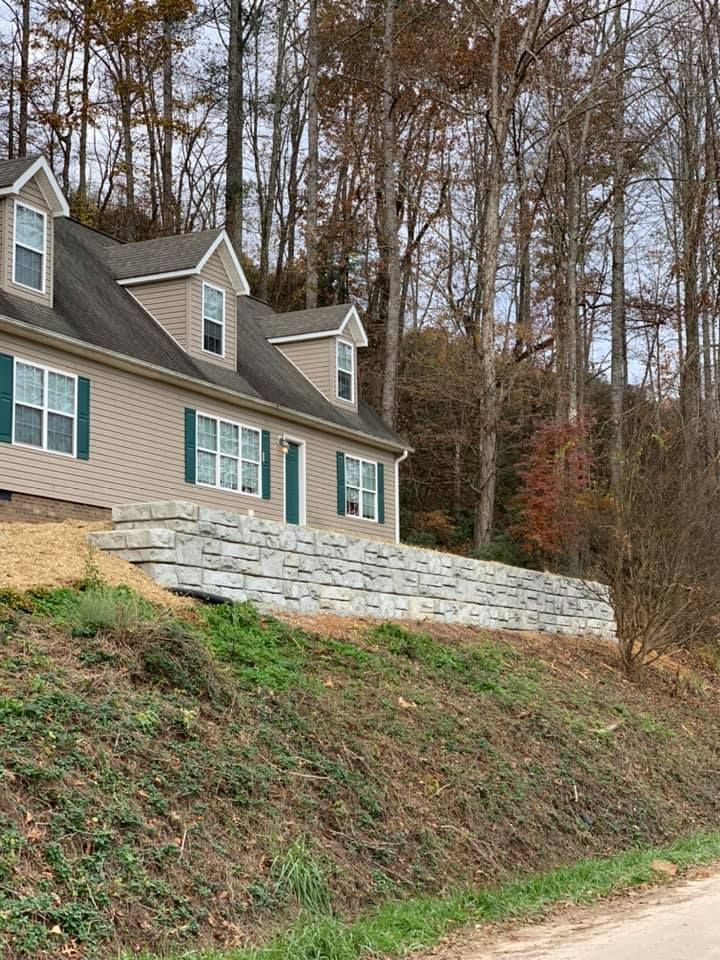 A house is sitting on top of a hill next to a road.