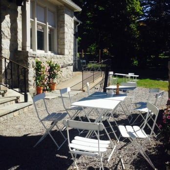 White folding tables and chairs in front of a stone building