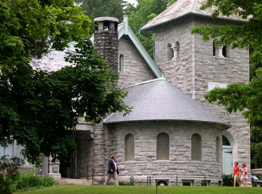 People are walking in front of a large stone building