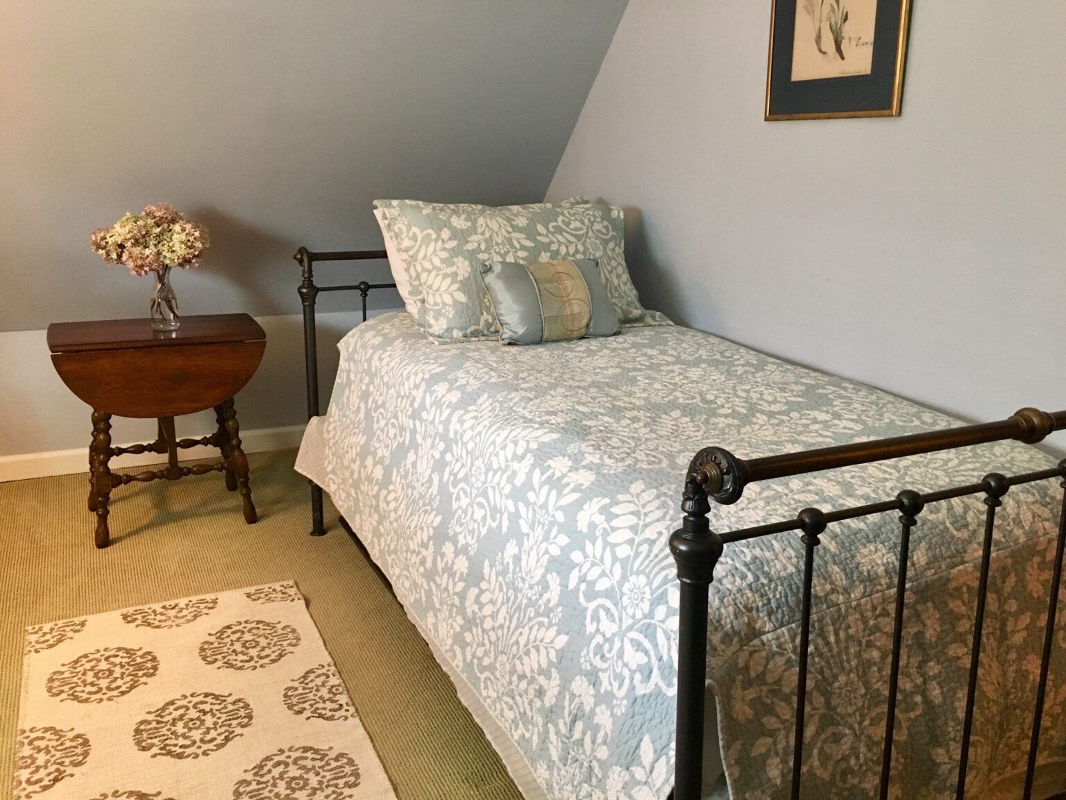 A bedroom with a single bed and a small table